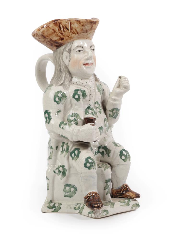 A Staffordshire Pottery Squire Toby Jug, 19th century, the seated figure with brown hat and green