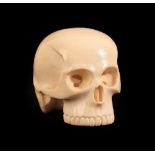 A Japanese Ivory Okimono as a Skull, Meiji period, naturalistically carved, signed to red lacquer