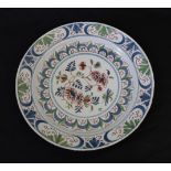 An English Delft Plate, mid 18th century, painted in colours with a central flowerspray within