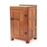 Robert Mouseman Thompson (1876-1955): An English Oak Panelled Bedside Cupboard, 1930's, with
