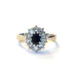 A sapphire and diamond cluster ring, finger size K. The ring is hallmarked however the fineness mark
