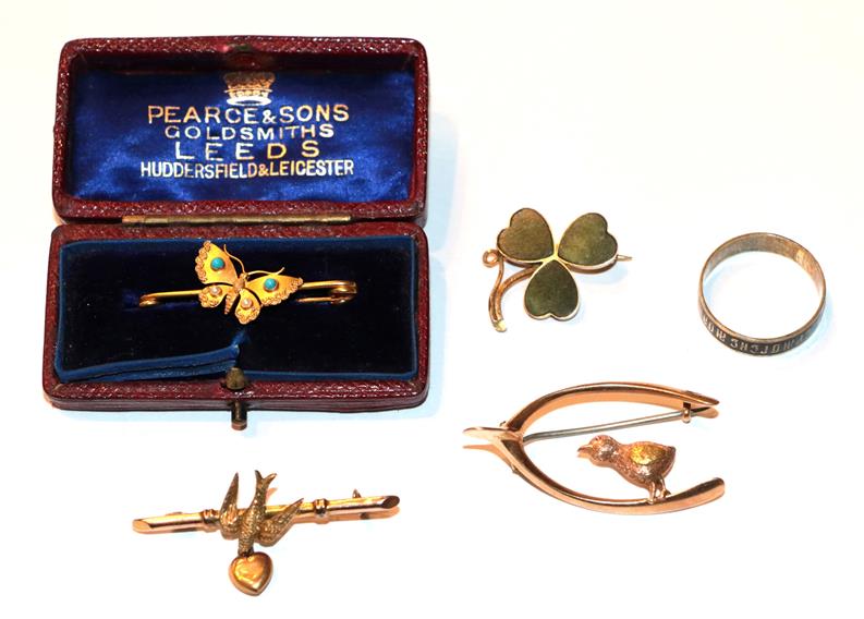 A 9 carat gold swallow bar brooch, length 4.2cm; a 9 carat gold shamrock brooch; a butterfly brooch,