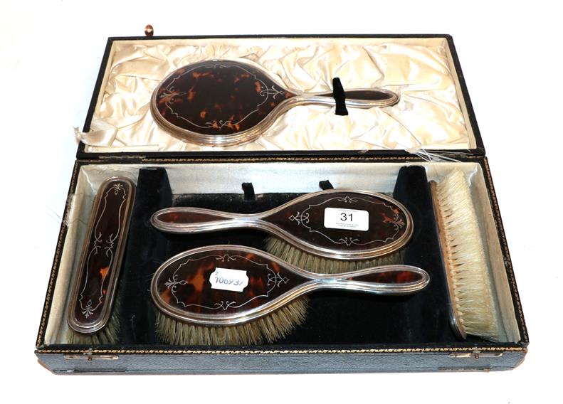 A silver and tortoiseshell cased dressing table set