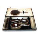 A silver and tortoiseshell cased dressing table set