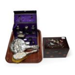 A travelling silver plated dressing table set, a silver backed hand cherub hand mirror and a