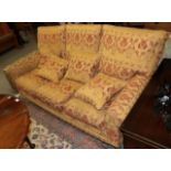 A cottage sofa upholstered in gold floral fabric