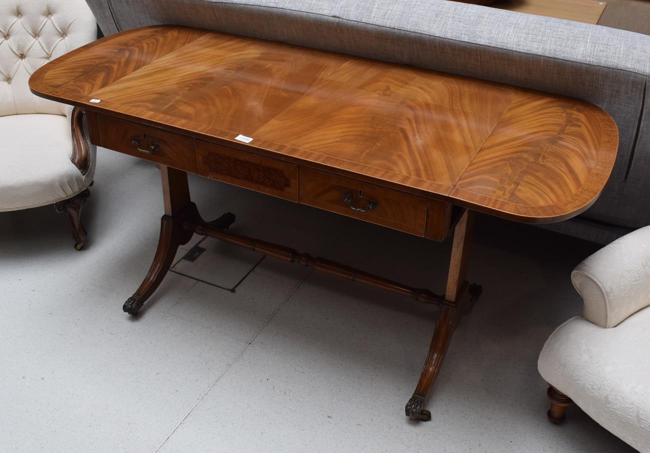 A reproduction mahogany and crossbanded sofa table in the Regency style