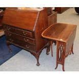 An early 20th century carved mahogany bureau and an Edwardian satinwood banded Sutherland table