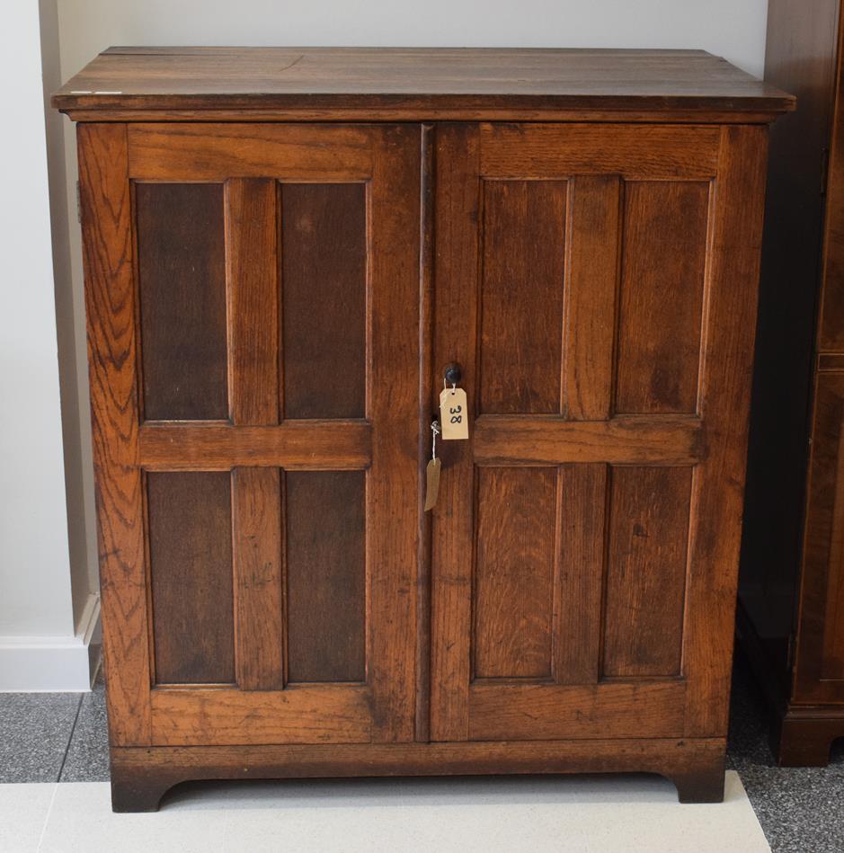 An oak double door cabinet enclosing eight trays, 112cm wide