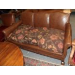 An early 20th century three-seater sofa, covered in brown close-nailed leather