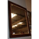 A wall mirror with grain painted frame