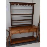 A reproduction oak three-drawer dresser base, with a pot board shelf, 126cm wide