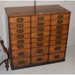 An early 20th century oak filing chest comprising twenty-four drawers, formerly from a printers