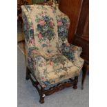 A 19th century wing back chair in William & Mary style, with floral loose cover, rounded arms and
