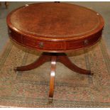 A reproduction library drum table with a brown leather top in the Georgian style