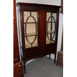 An Edwardian mahogany display cabinet, with blind fret carved frieze above glazed doors