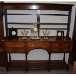 A George III oak open dresser, late 18th century, the rack with moulded pediment above a shelf,