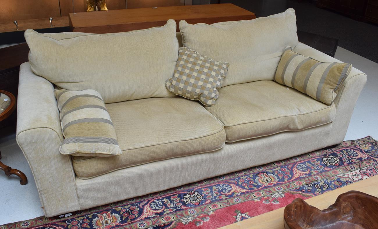 A modern three-seater sofa in pale corduroy fabric