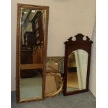 An early 20th century brass framed mirror; three gilt mirrors; and an Edwardian carved mahogany
