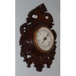 An Edwardian carved oak cased aneroid barometer