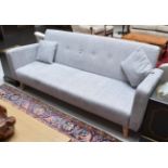 A modern three-seater sofa covered in grey fabric with beech legs