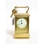A French brass carriage timepiece with enamel dial with blue Arabic numerals