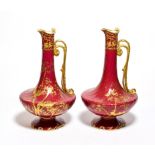 A pair of Royal Crown Derby floral gilt decorated red ground ewers, 25cm high