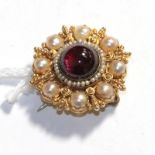 A garnet and cultured pearl brooch/pendant, 2.6cm diameter . Unmarked. Gross weight 8.00 grams.