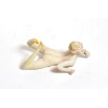 An early 20th century German bisque figure of a nude young woman, unmarked, modelled lying on