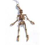 An articulated skeleton motif pendant, unmarked, length 10.4cm . Gross weight 21.47 grams