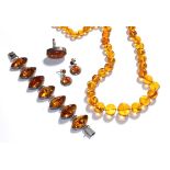 An amber type suite comprising a necklace, a bracelet, a ring and a pair of drop earrings . All