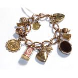 A charm bracelet, each link stamped '9' and '375' hung with various charms including a hard stone