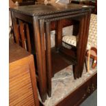 A late Victorian oak framed adjustable gout stool and a nest of three tables