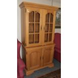 A reproduction oak display cabinet with two glazed doors and two cupboard doors