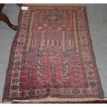 An Afghan prayer rug, the raspberry field depicting a mosque enclosed by octagon borders, 135cm by