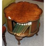 A 1930s burr walnut revolving bookcase table bearing labels from Simpsons, Silver Street, Halifax