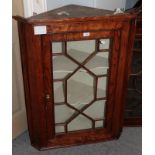 A George III elm hanging corner cupboard with glazed door