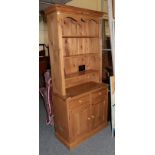 A pine bookcase cabinet together with pine and tile-top kitchen table