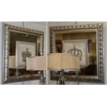 A pair of modern square form mirrors with silvered and carved frames