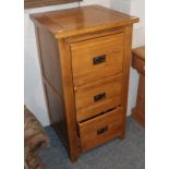 A reproduction oak three drawer filing cabinet