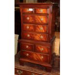 A reproduction mahogany miniature chest on chest