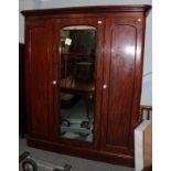 A Victorian mahogany triple door wardrobe, late 19th century, the moulded cornice above three arched