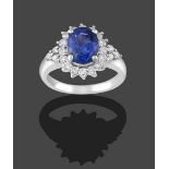 A Sapphire and Diamond Cluster Ring, the oval cut sapphire within a border of round brilliant cut