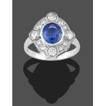 A Sapphire and Diamond Cluster Ring, the oval cut sapphire within a border of round brilliant cut