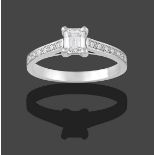 A Platinum Diamond Solitaire Ring, the emerald-cut diamond in a four claw setting, to round
