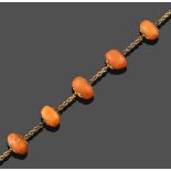 An Amber Bead Necklace, a yellow ropetwist chain spaced by seven irregular shaped amber beads,