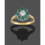 An 18 Carat Gold Emerald and Diamond Cluster Ring, the round brilliant cut diamond within a border