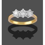 A Diamond Three Stone Ring, the round brilliant cut diamonds in white claw settings, on a yellow