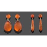 A Pair of Amber Drop Earrings, a circular cabochon amber suspends a pear shaped cabochon amber, in