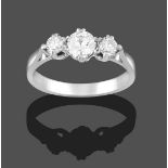 A Diamond Three Stone Ring, the graduated round brilliant cut diamonds in white claw settings, on